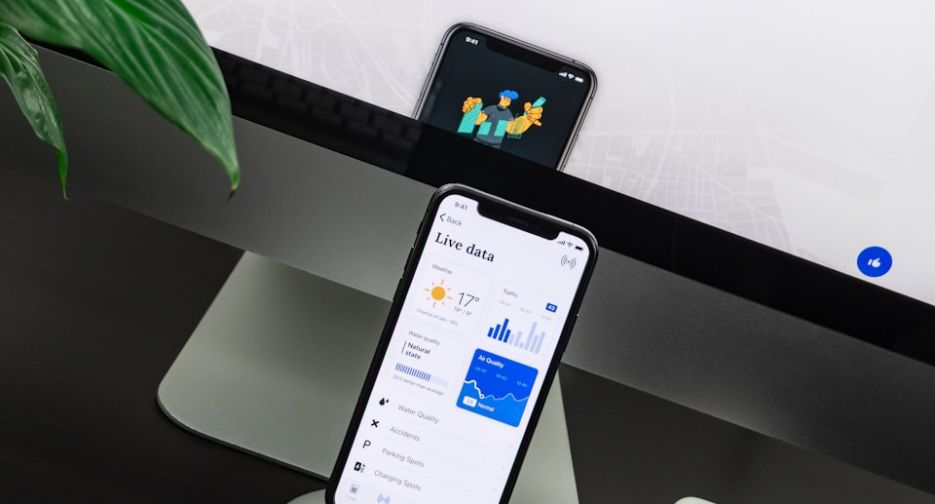 space gray iPhone X on stand near silver iMac and Apple Magic Keyboard